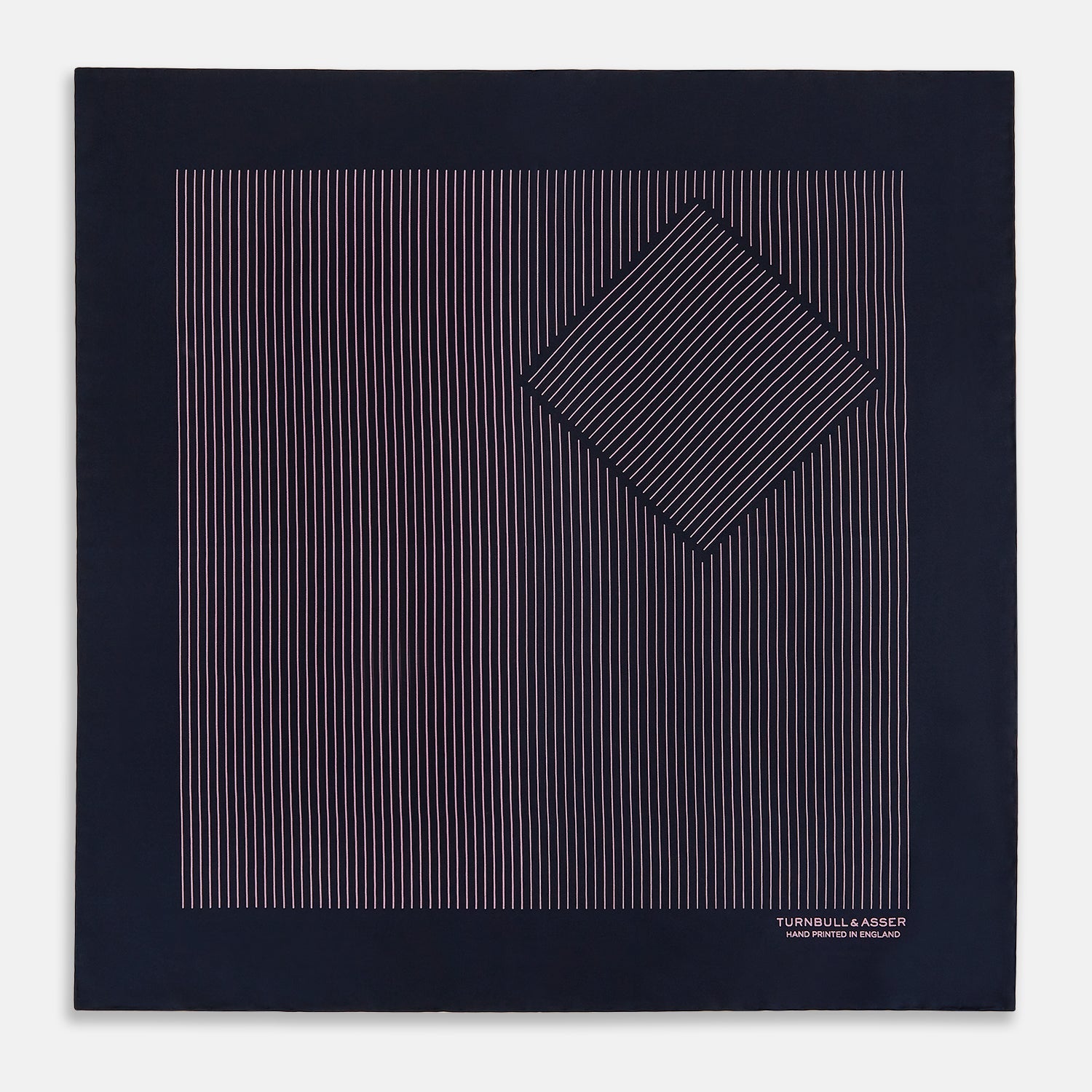View 3 of product The Navy and Pink Stripe Silk Pocket Square by Turnbull & Asser features thin pink stripes, a geometric border, hand-rolled edges, and "TURNBULL & ASSER HAND PRINTED IN ENGLAND" printed in white.