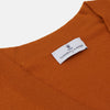 View 2 of product The Rust Lachlan Cashmere Cardigan by Turnbull & Asser features a V-neck, long sleeves, front button closure, and two front pockets—ideal for layering in smart-casual looks. Shown laid flat on a plain white background.