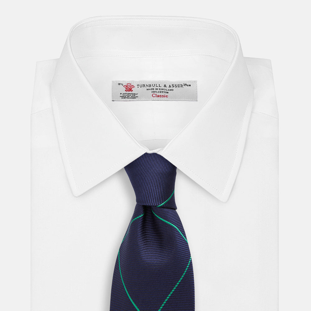 The Turnbull & Asser Green and Navy Window Pane Silk Tie features a subtle ribbed texture with a diagonal green grid pattern, inspired by archival designs—a stylish choice for modern office attire.