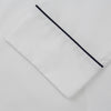 View 3 of product The Turnbull & Asser Women's Harriet Plain White Cotton Pyjama Set features long sleeves, black piping, a chest pocket, and matching pants with elastic waistband and ribbon tie, all displayed on a white background.