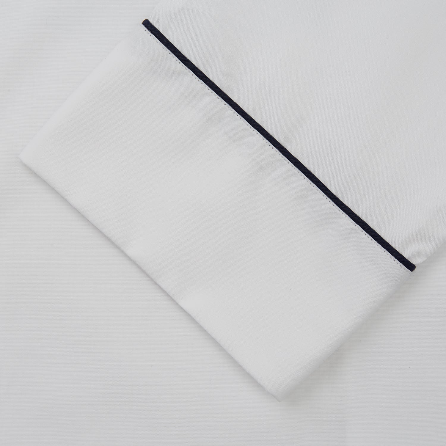 View 3 of product The Turnbull & Asser Women's Harriet Plain White Cotton Pyjama Set features long sleeves, black piping, a chest pocket, and matching pants with elastic waistband and ribbon tie, all displayed on a white background.