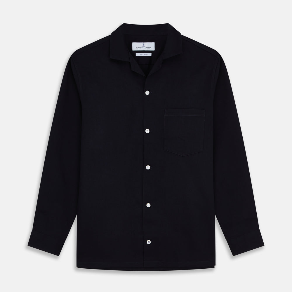 A Navy Cotton Holiday Fit Winnington Shirt by Turnbull & Asser, featuring long sleeves, a chest pocket, white buttons, and a revere collar, is laid flat on a white background.