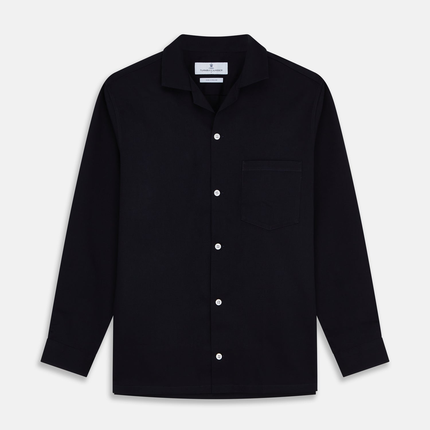 View 1 of product A Navy Cotton Holiday Fit Winnington Shirt by Turnbull & Asser, featuring long sleeves, a chest pocket, white buttons, and a revere collar, is laid flat on a white background.