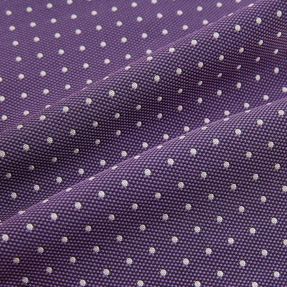 The Lilac and Purple Micro Dot Silk Cravat by Turnbull & Asser features evenly spaced white dots—offering an elegant, handmade accent to your formal ensemble or pocket square collection.