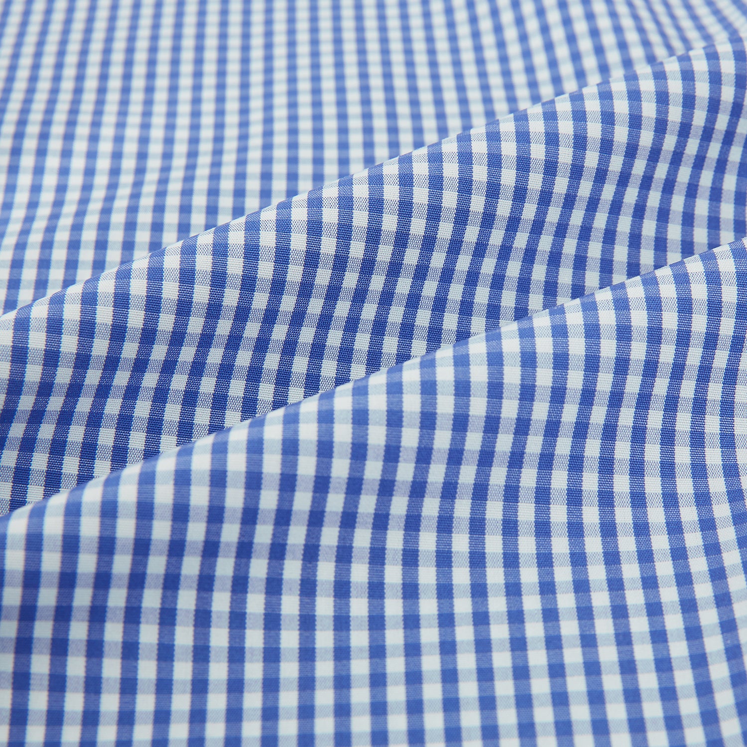 View 6 of product The Turnbull & Asser Blue Grid Check Belgravia Shirt, made from pure cotton with long sleeves, a spread collar, buttoned cuffs, and a blue-and-white check pattern, is laid flat on a white background.