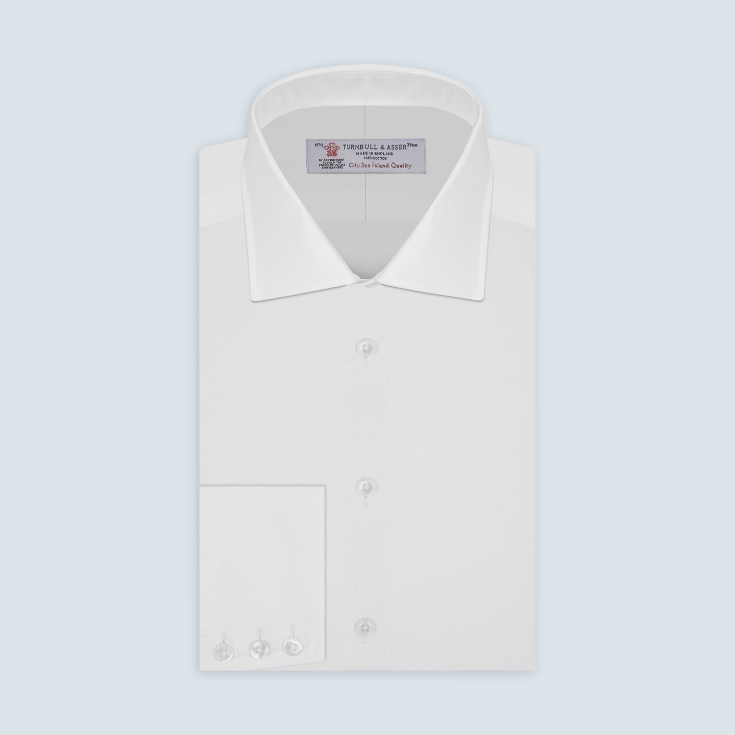 View 1 of product The Sea Island Cotton Classic Fit White Shirt by Turnbull & Asser features a classic collar and front buttons, neatly folded with its label visible, displayed on a light blue background.