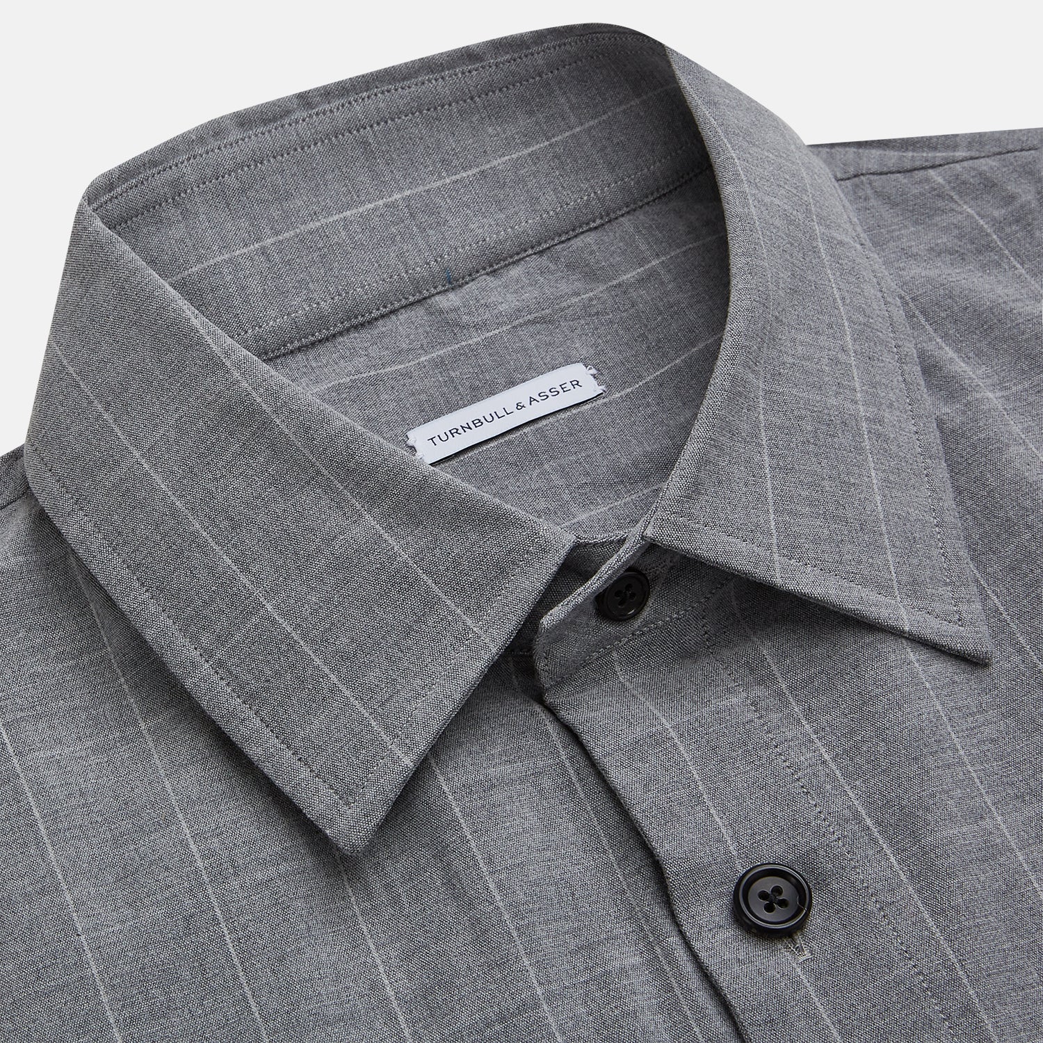 View 2 of product The Turnbull & Asser Grey Check Hampstead Overshirt features a light gray check pattern, pointed collar, chest pocket, and two zippered side pockets, displayed flat against a white background.