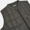 View 2 of product The Shadow Grey Quilted Gilet by Turnbull & Asser is a sleeveless, lightweight layer featuring a front zipper, two zippered side pockets, one chest pocket, and a rounded hem—shown on a plain white background.