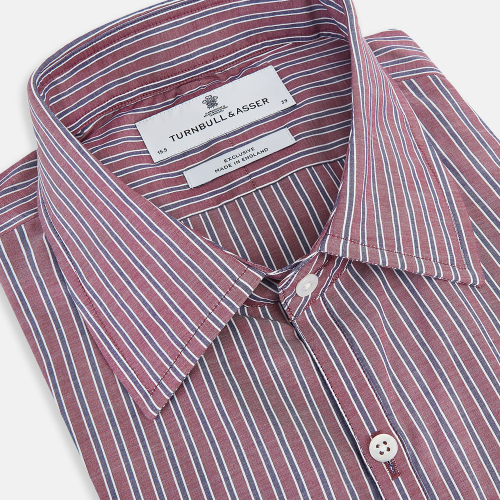 The Turnbull & Asser Wine Ticking Stripe Westminster Shirt features red, blue, and white vertical pinstripes on white and is shown laid flat on a white surface.