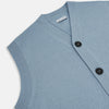 View 2 of product The Turnbull & Asser Frost Blue Cashmere Sleeveless Cardigan features a V-neck, five black buttons, two front pockets, and ribbed trim—ideal for layering in sophisticated outfits.