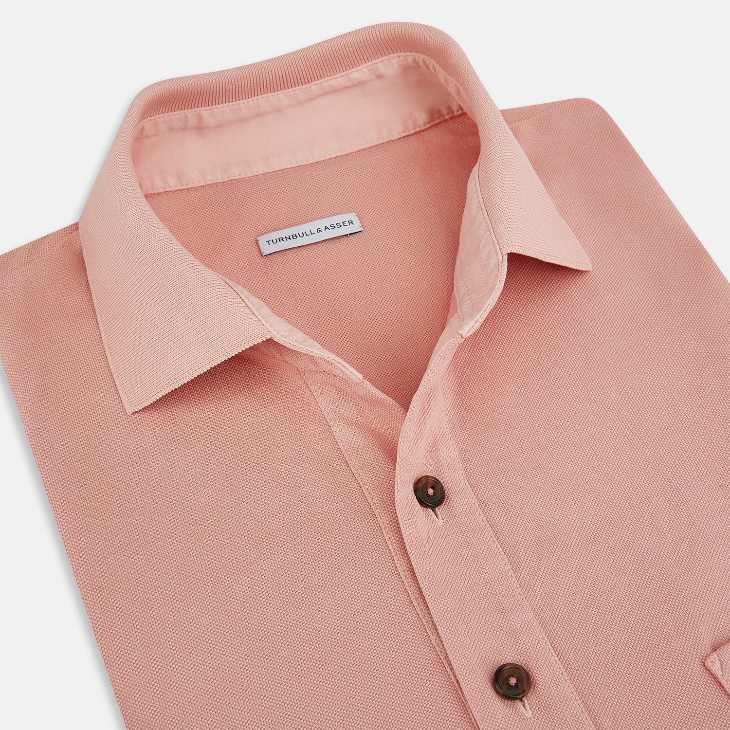 View 2 of product The Orange Polo Shirt by Turnbull & Asser features short sleeves, a collar, three-button placket, and a small buttoned chest pocket in soft cotton jersey—timeless men's style laid flat on a white background.