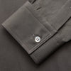 View 3 of product The Turnbull & Asser Dusty Sage Cotton Drill Weekend Fit Nevis Shirt features a button-down collar, long sleeves, two chest pockets, and white buttons, shown folded on a white background.