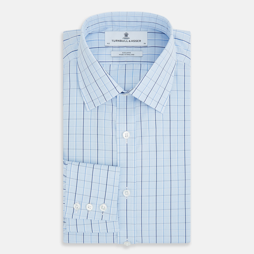 The Navy and Blue Combination Check Mayfair Shirt by Turnbull & Asser features a light blue base with a grid of thin dark blue lines, long sleeves, a pointed collar, and is neatly displayed on a plain white background.