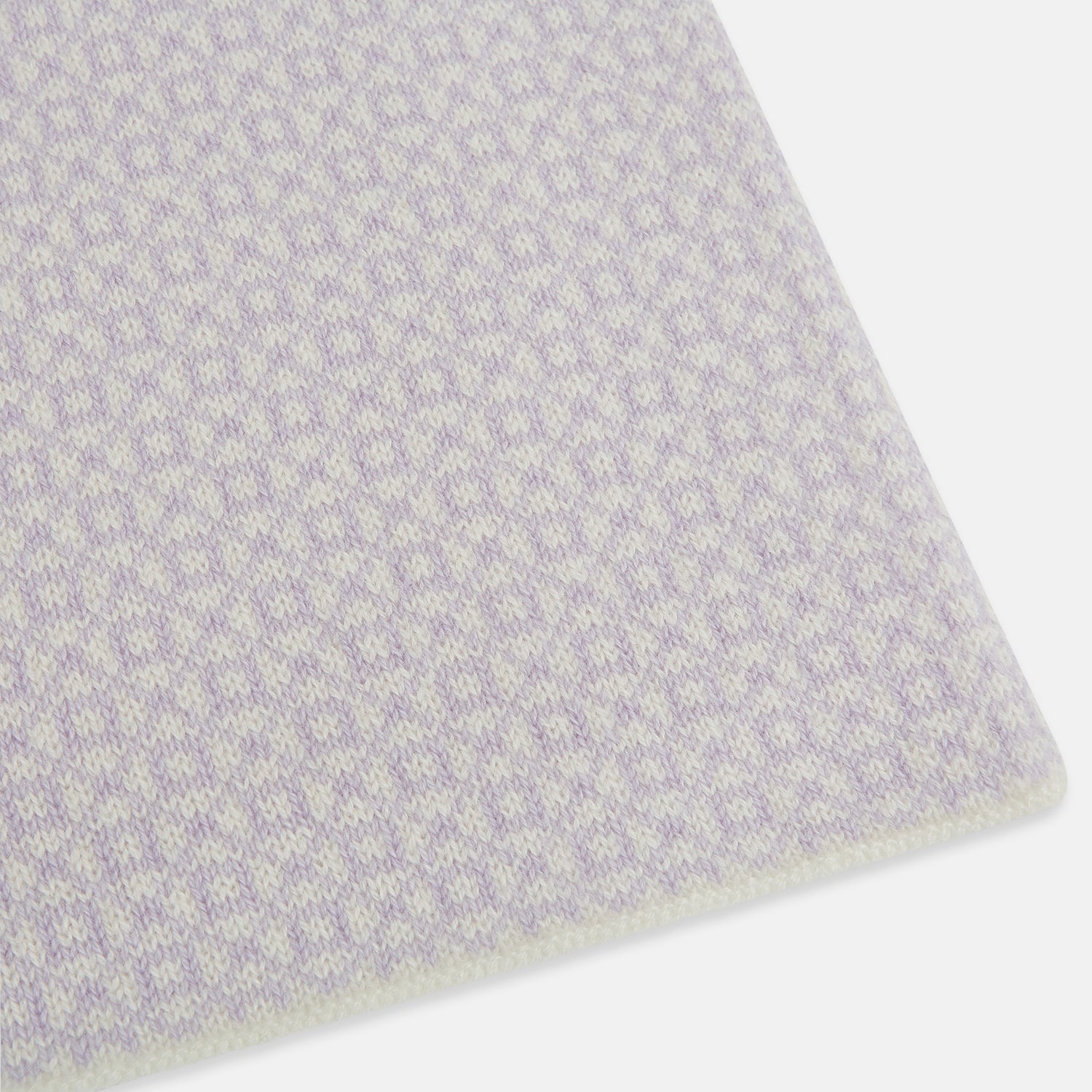 View 2 of product The Turnbull & Asser Ivory and Lilac Lozenge-Patterned Cashmere Knitted Scarf, tied loosely, reveals its refined style and geometric design against a plain white background.