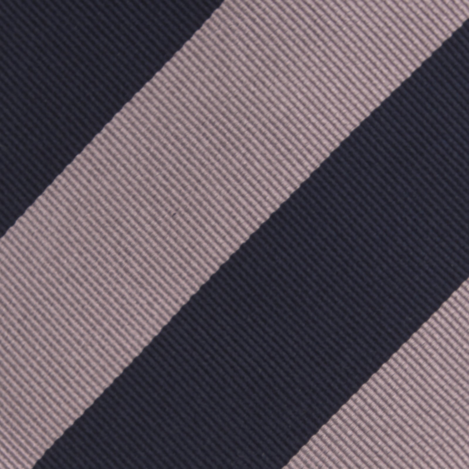View 4 of product The Turnbull & Asser Navy and Rose Block Stripe Repp Silk Tie, crafted from luxurious silk, features bold diagonal stripes and is displayed rolled up on a plain white background.