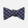 View 1 of product The Turnbull & Asser Navy and Blue Houndstooth Wool Blend Bow Tie features a self-tying design with a blue and black houndstooth pattern, showcased on a plain white background.