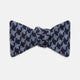 The Turnbull & Asser Navy and Blue Houndstooth Wool Blend Bow Tie features a self-tying design with a blue and black houndstooth pattern, showcased on a plain white background.