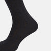 View 4 of product A single Charcoal/Brown Dash Striped Long Sock by Turnbull & Asser, made from mercerised Egyptian cotton, stands upright on a plain light background, showcasing its ribbed texture and fitted design.