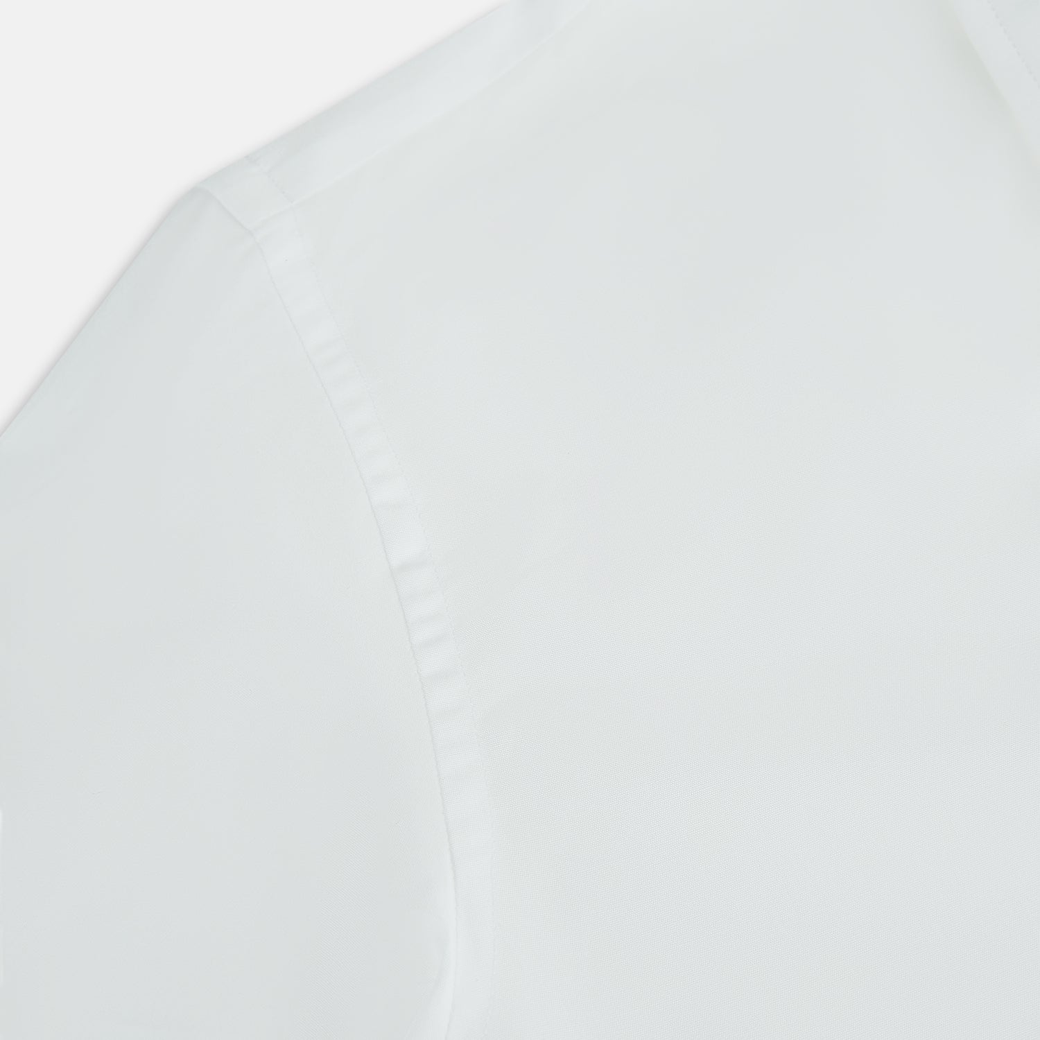 View 6 of product The PLAIN WHITE WESTMINSTER SHIRT WITH TURNBULL COLLAR AND 3-BUTTON CUFFS by Turnbull & Asser features refined British craftsmanship, long sleeves, a straight hem, and a crisp white design displayed on a plain background.