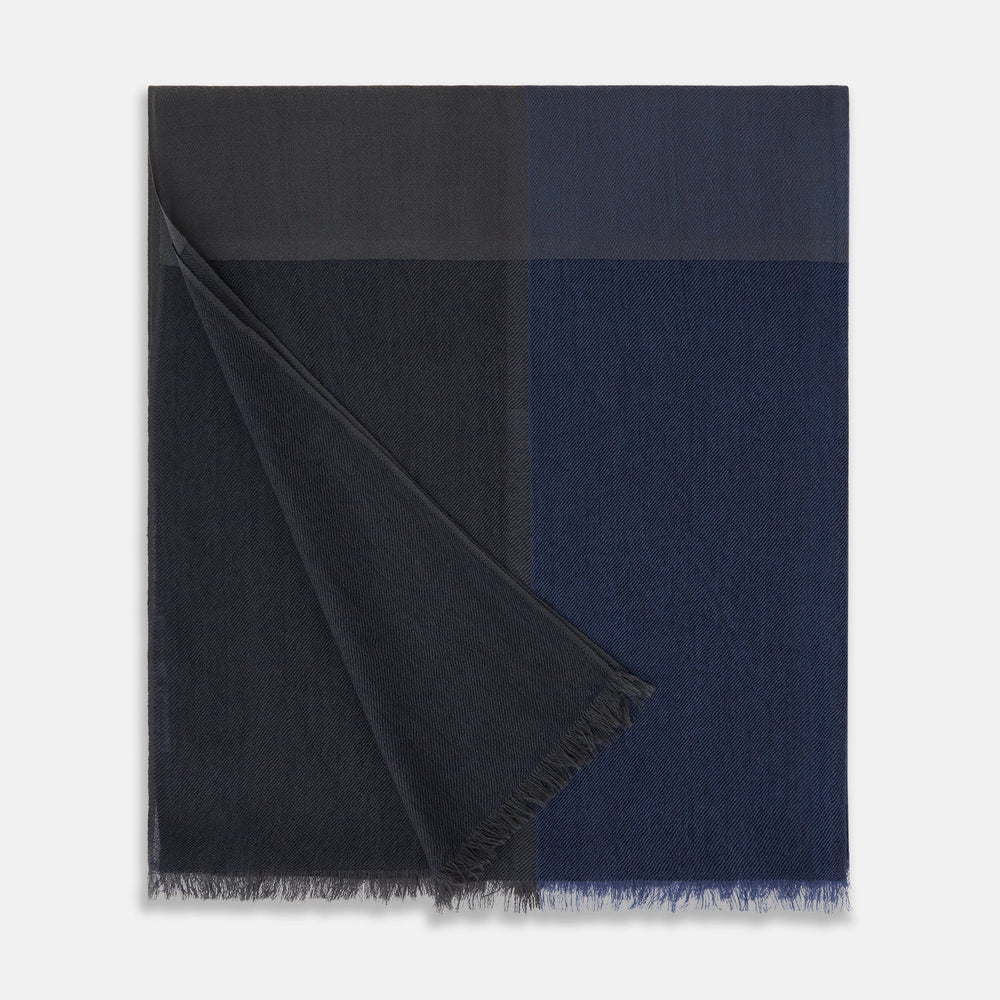 The Charcoal and Navy Cashmere Scarf by Turnbull & Asser features a color block design in dark hues, raw fringed edges, and a soft, smooth texture, elegantly displayed against a white background.