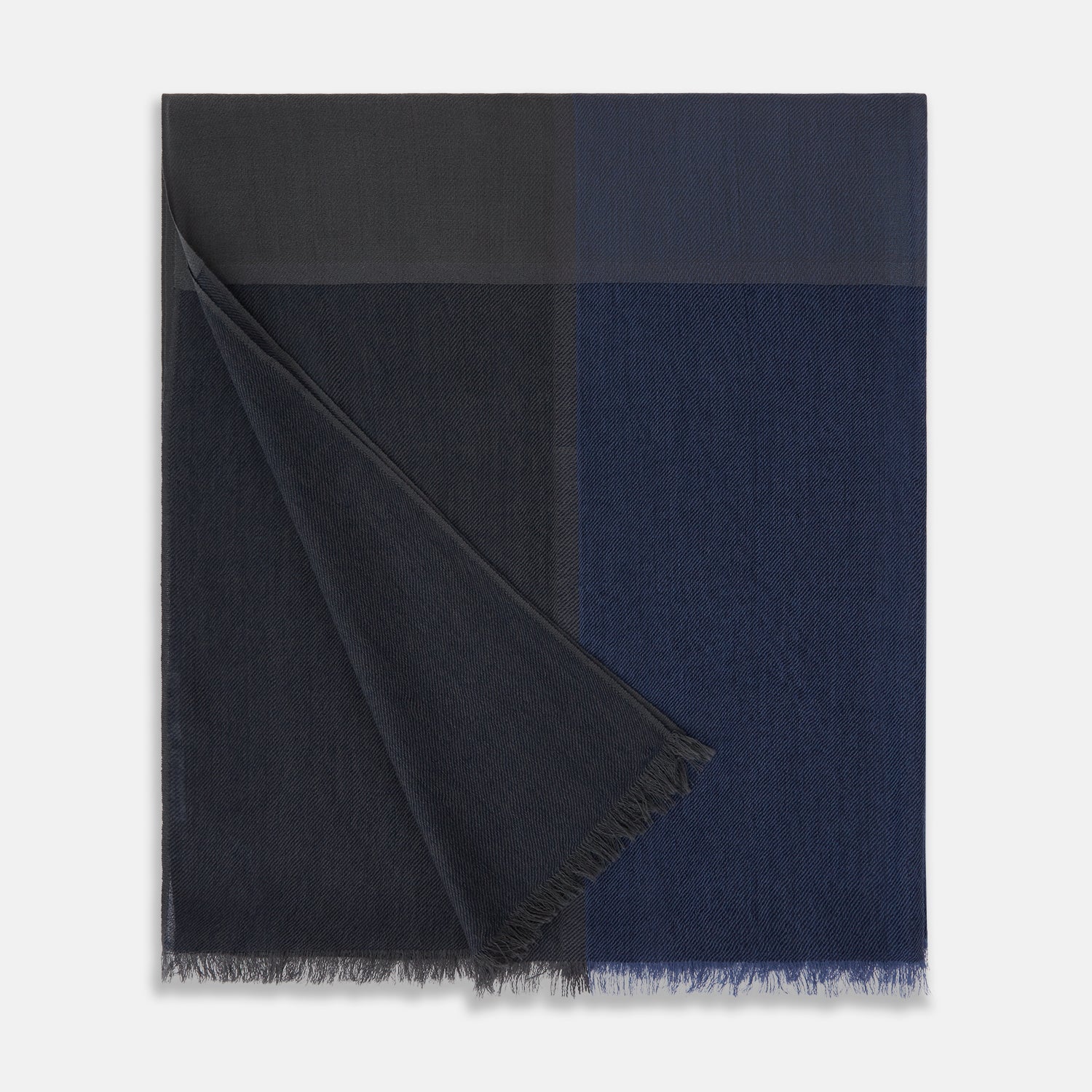 View 3 of product The Charcoal and Navy Cashmere Scarf by Turnbull & Asser features a color block design in dark hues, raw fringed edges, and a soft, smooth texture, elegantly displayed against a white background.