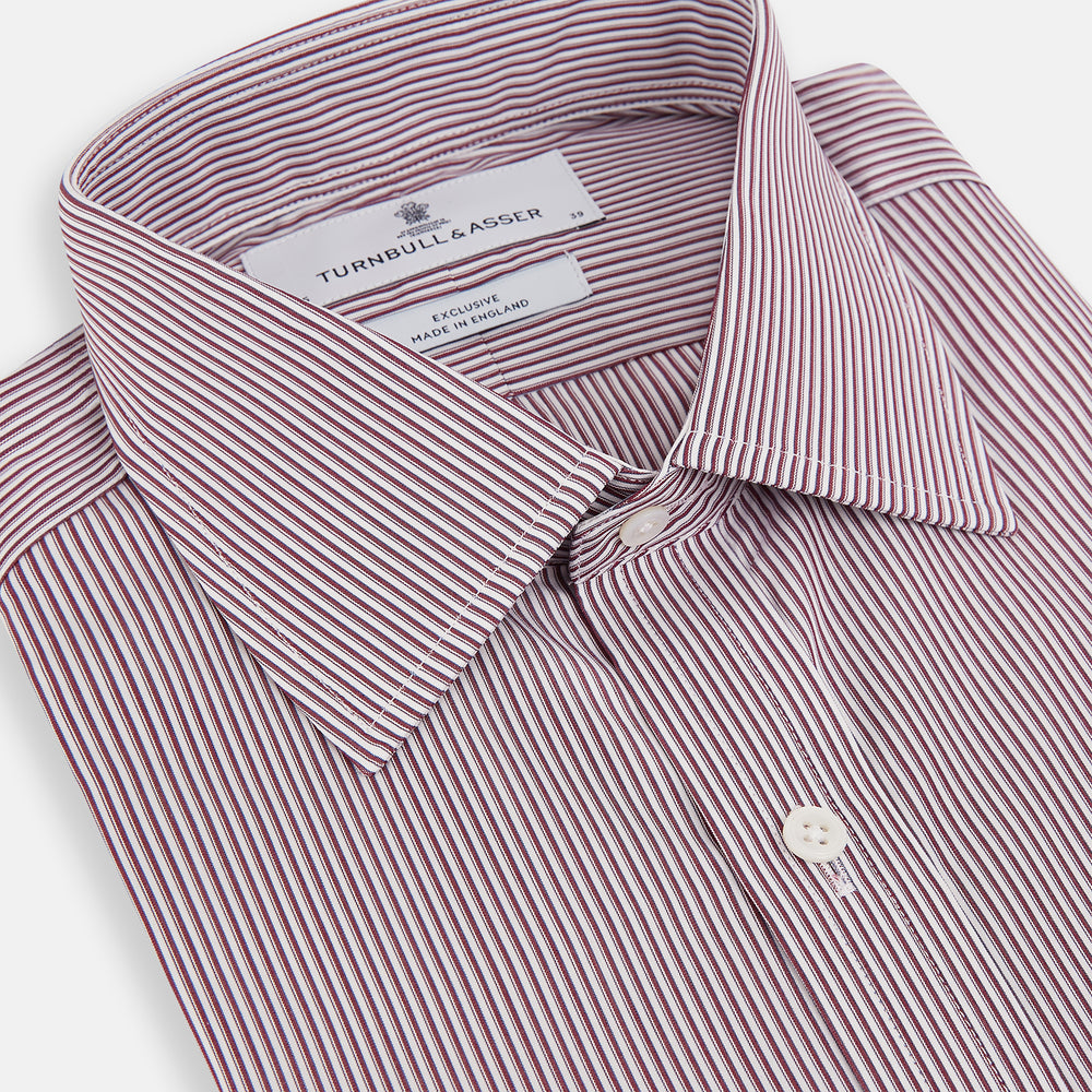 The Turnbull & Asser Burgundy Shadow Stripe Mayfair Shirt is a long-sleeved button-up with thin vertical burgundy stripes, classic collar, and buttoned cuffs, shown laid flat on a white background.