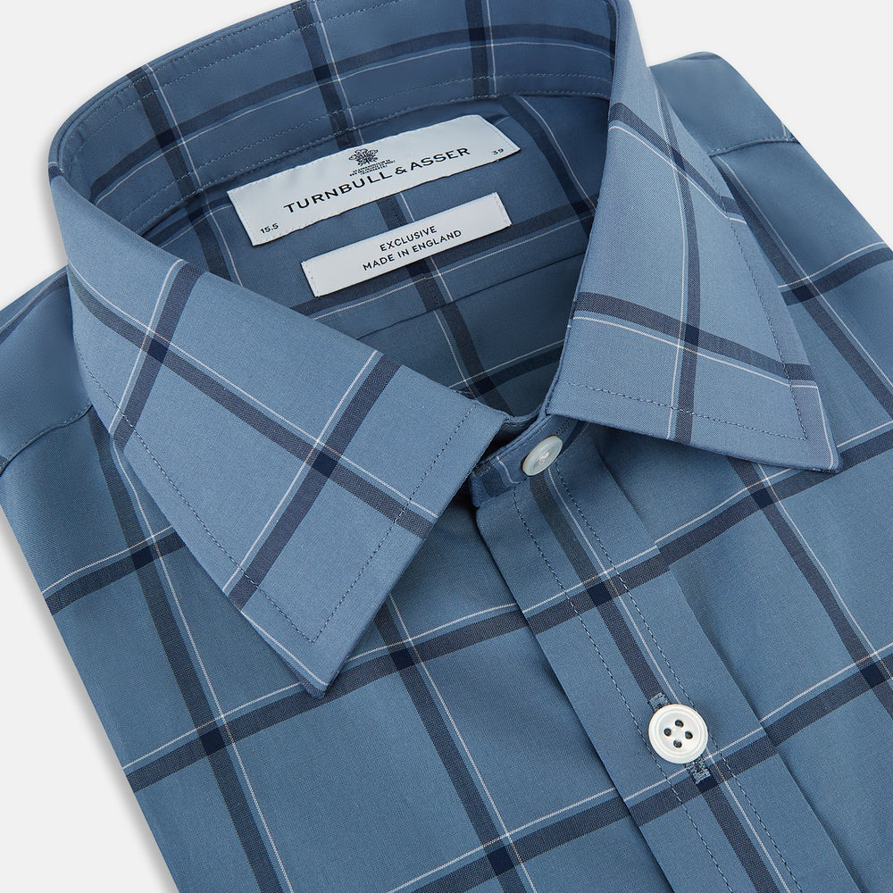 The Turnbull & Asser Steel Grey Grid Check Mayfair Shirt is a long-sleeve, button-up shirt in light blue Italian cotton, shown against a plain white background.