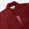 View 3 of product The Turnbull & Asser Burgundy Linen & Cotton Cord Gown, expertly made in England, features a shawl collar, patch pockets, and a matching fabric belt—shown here on a white background.
