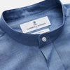 View 4 of product The Turnbull & Asser Blue Cotton Weekend Fit Blake Shirt features a light blue color, long sleeves, stand collar, white buttons, and a curved hem—ideal for casual weekends. Laid flat on a white background.