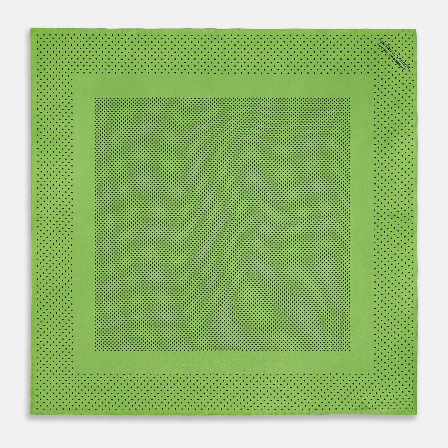 View 4 of product The Turnbull & Asser Kelly Green Dot Silk Pocket Square features small black polka dots and is shown neatly folded to showcase both its front and inner sides.