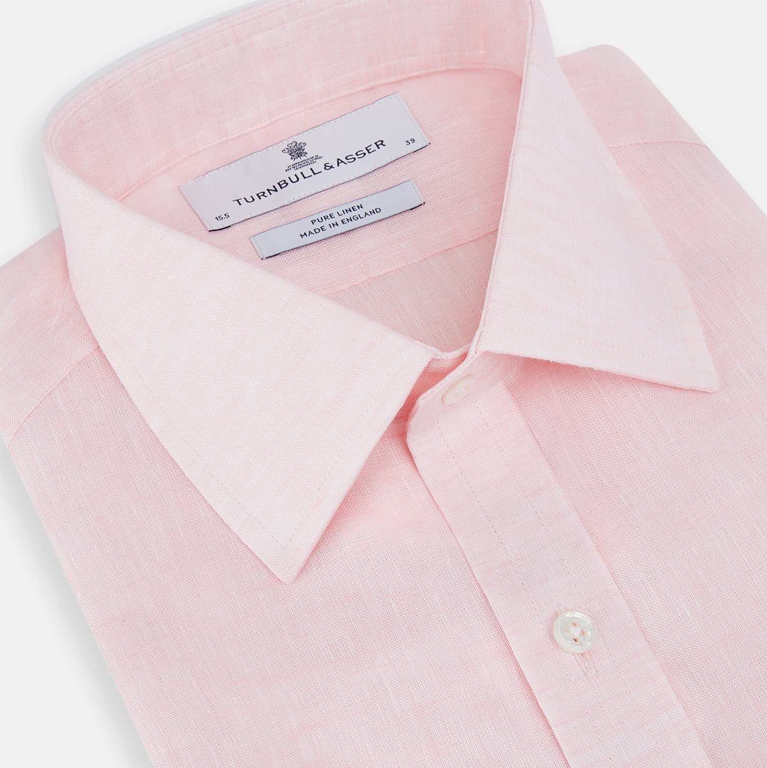 View 2 of product The Turnbull & Asser Pale Pink Linen Mayfair Shirt features a classic, formal style with long sleeves, a collar, and white buttons. Shown laid flat on a white background.