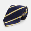 View 1 of product The Yellow and White Blazer Silk Tie by Turnbull & Asser, featuring diagonal white and yellow stripes on navy blue, is shown rolled up against a light gray background.