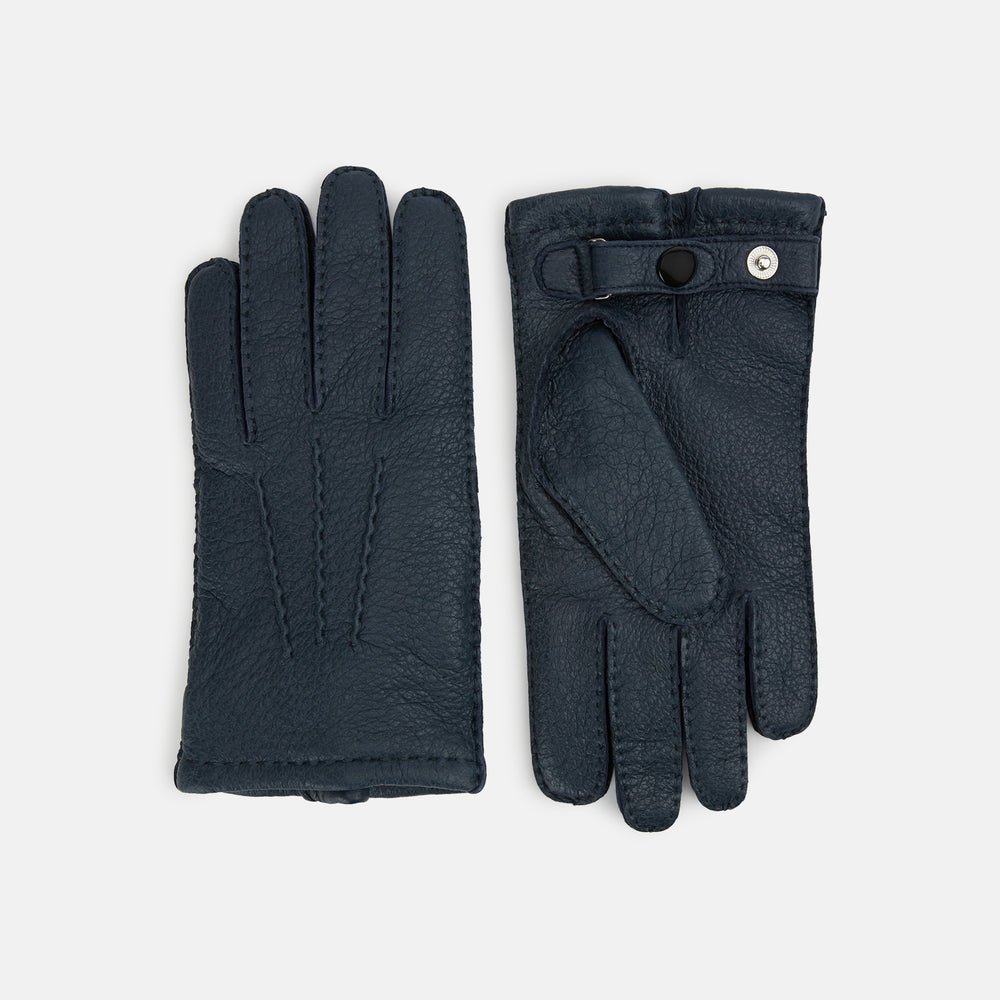 A pair of Turnbull & Asser Navy Cashmere-Lined Peccary Leather Gloves, one showing the palm with a buttoned strap and the other the back with decorative stitching, elegantly displayed on a white background.