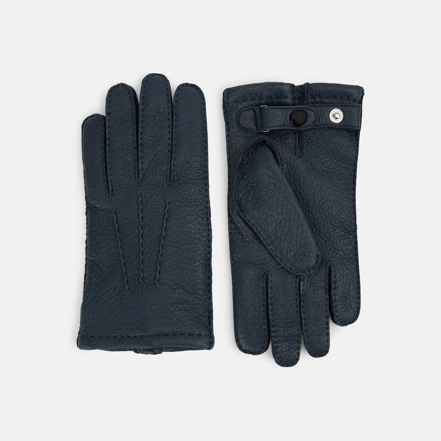 View 1 of product A pair of Turnbull & Asser Navy Cashmere-Lined Peccary Leather Gloves, one showing the palm with a buttoned strap and the other the back with decorative stitching, elegantly displayed on a white background.