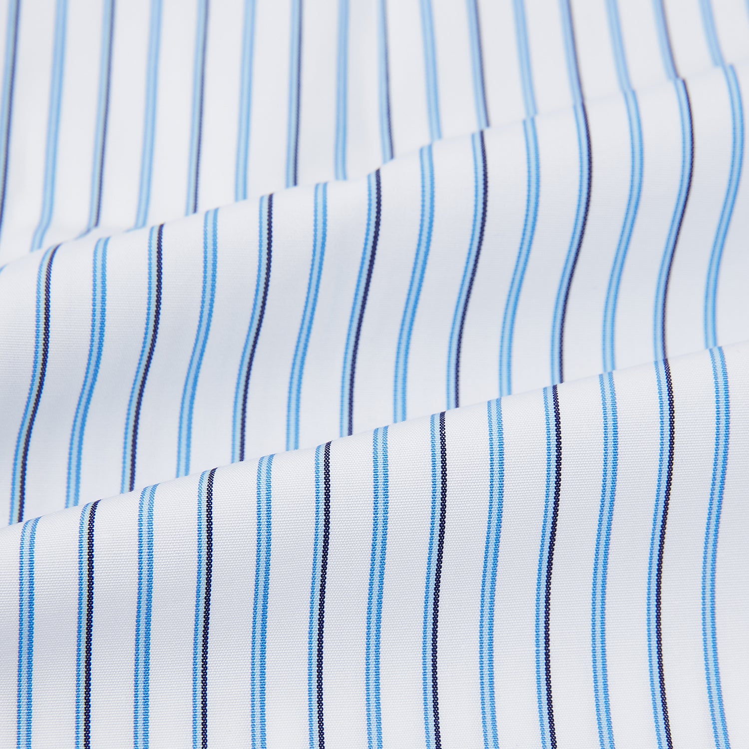 View 6 of product The Blue and Navy Double Stripe Mayfair Shirt by Turnbull & Asser features a classic T&A collar and thin blue stripes on a white background, displayed against a plain white surface.
