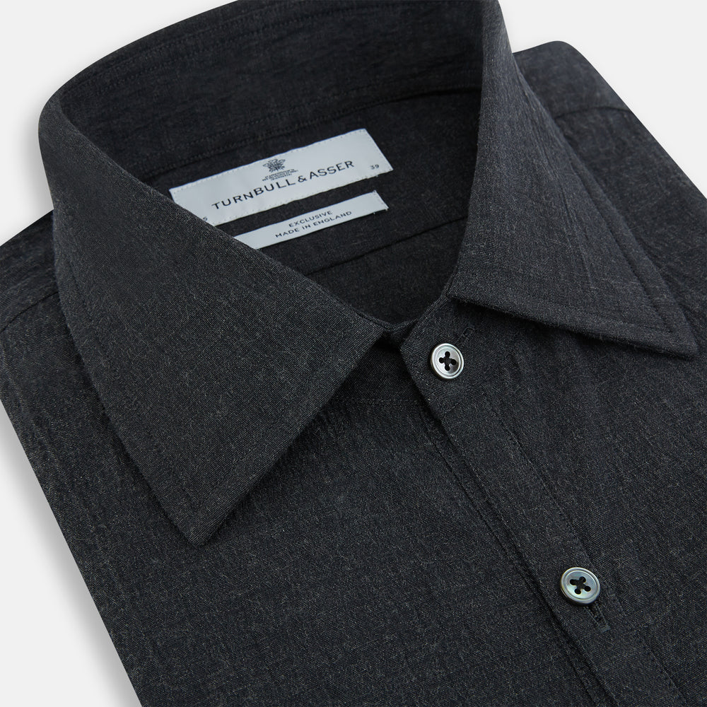 The Turnbull & Asser Midnight Blue Westminster Shirt features long sleeves, a button-up front, classic collar, and buttoned cuffs in a plain design—showcasing British craftsmanship—laid flat on a white background.