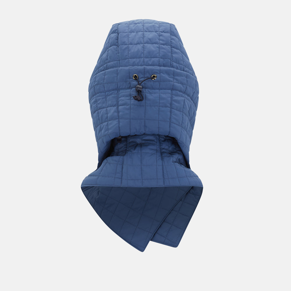 The Turnbull & Asser Azzurro Quilted Hood with Neck Warmer features a grid-stitched pattern, button closure, and overlapping front for added style. It draws inspiration from classic quilted jackets and is shown on a plain white background.