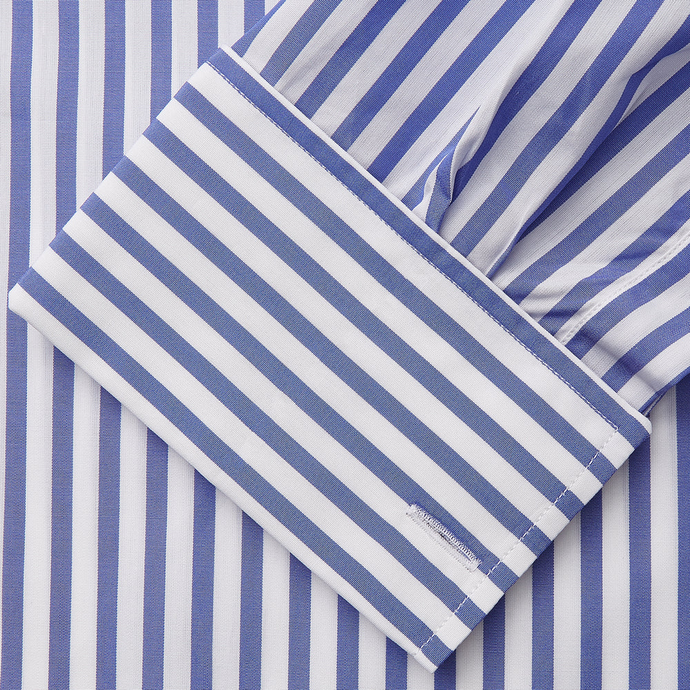 The Turnbull & Asser Pale Blue Candy Stripe Cotton Marlene Shirt is an oversized women's collared shirt with long sleeves, buttoned cuffs, and vertical blue and white stripes, shown laid flat on a white background.