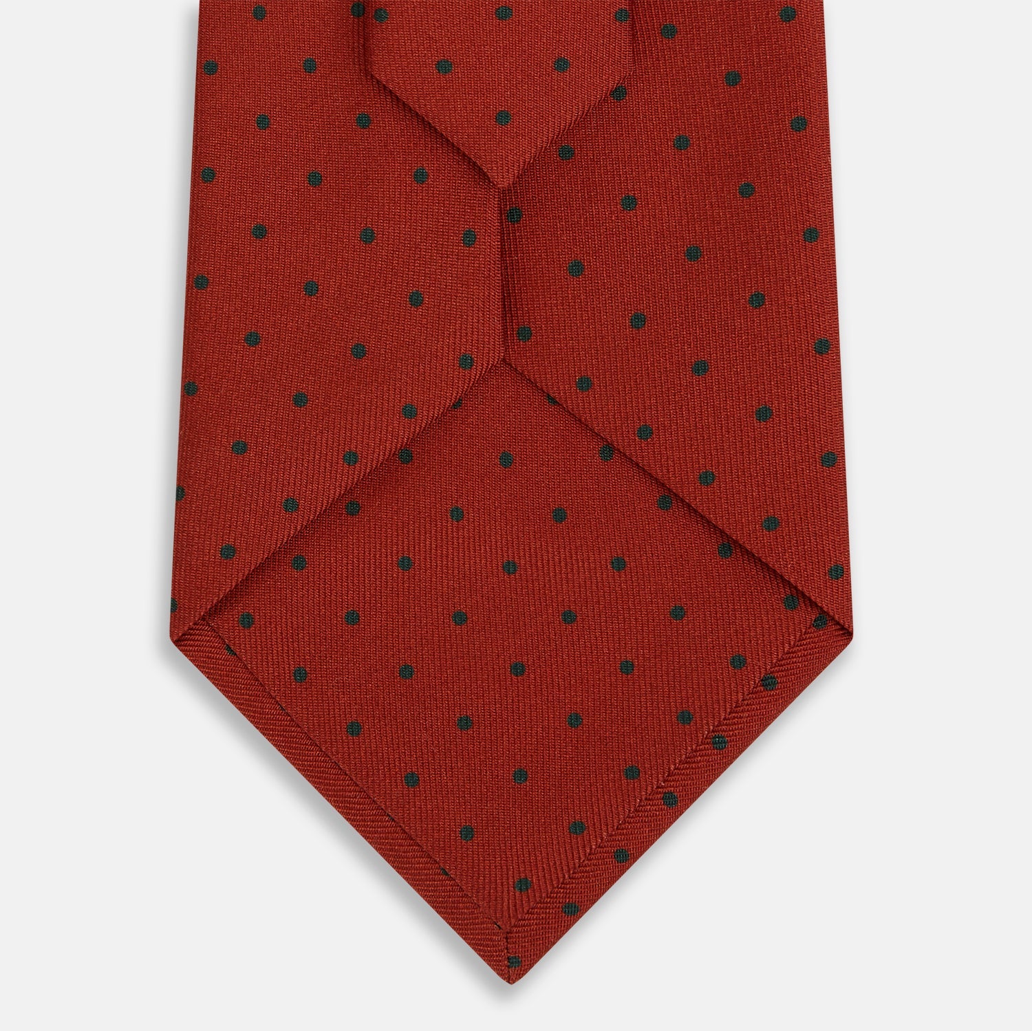 View 3 of product The Turnbull & Asser Red and Navy Polka Dot Silk Tie is elegantly rolled on a white background, highlighting classic British craftsmanship.