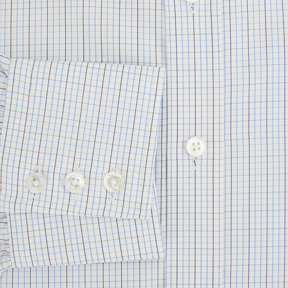 The Turnbull & Asser Pale Blue and Navy Grid Check Mayfair Shirt is a long-sleeve, button-up shirt made from fine Italian cotton, featuring a pointed collar and buttoned cuffs, shown against a plain white background.