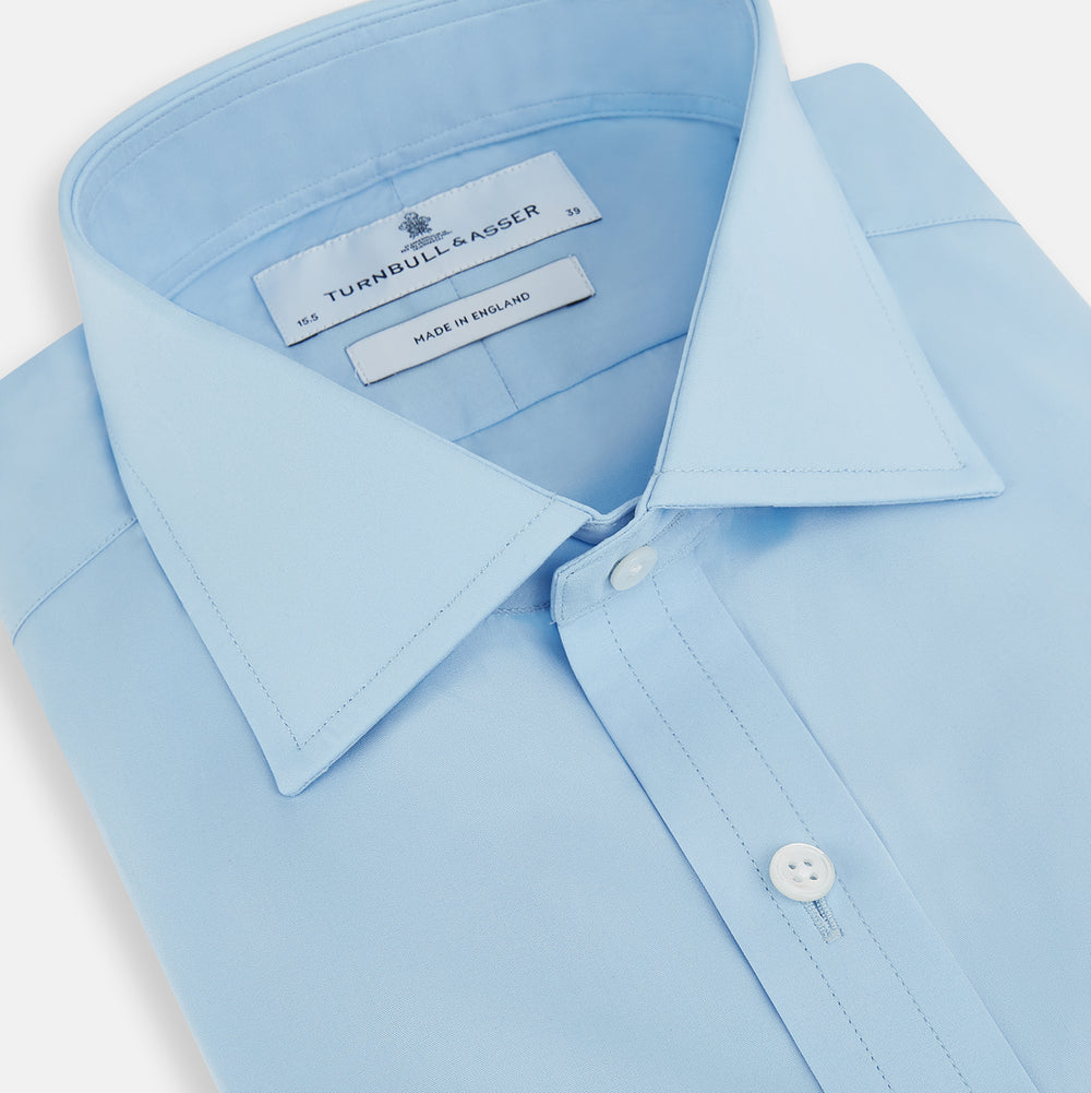 The Turnbull & Asser Dr. No Blue Cotton Shirt with cocktail cuffs, inspired by James Bond, features a classic collar and white buttons, displayed on a plain white background.