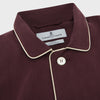 View 2 of product The Turnbull & Asser Plain Plum Silk Modern Pyjama Set, made in England, features white piping, a button-up long-sleeve top with three pockets, and matching pants. The pyjamas are shown against a white background.