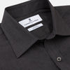 View 3 of product A man with short hair wears the Turnbull & Asser Black Check Weekend Fit Flannel Shirt with Derby Collar and 1-Button Cuffs, paired with light pants, against a plain background—ideal for a smart-casual weekend look.