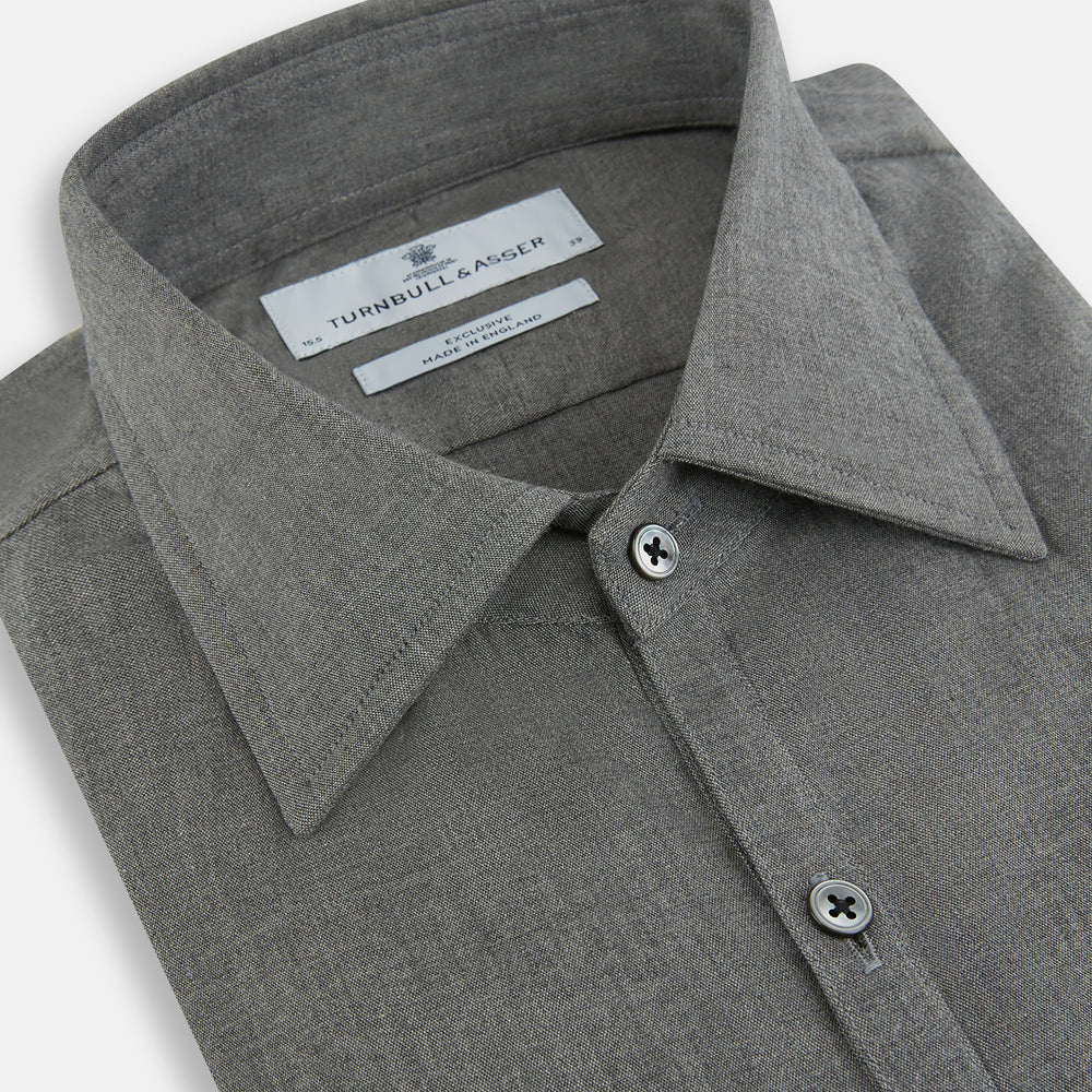 The Pale Charcoal Westminster Shirt by Turnbull & Asser features British craftsmanship with a tailored silhouette, long sleeves, pointed collar, buttoned cuffs, and a solid pale charcoal hue, elegantly shown against a white background.