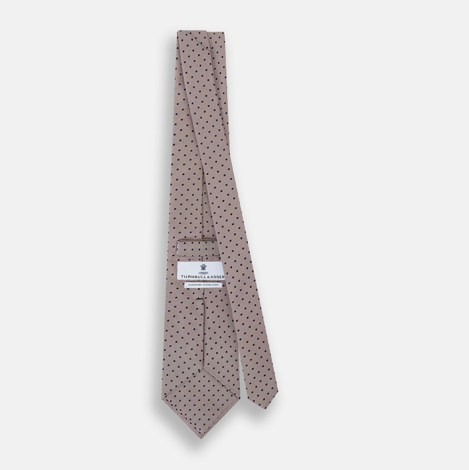 View 4 of product The Turnbull & Asser Navy and Lilac Micro Dot Silk Tie, featuring subtle micro dots, is the perfect refined accessory for smart outfits, shown rolled up against a plain white background.