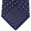 View 4 of product The Turnbull & Asser Navy and White Spot Woven Herringbone Silk Tie, shown rolled-up on a white background, features a classic polka dot pattern—an elegant accessory for refined wardrobes.