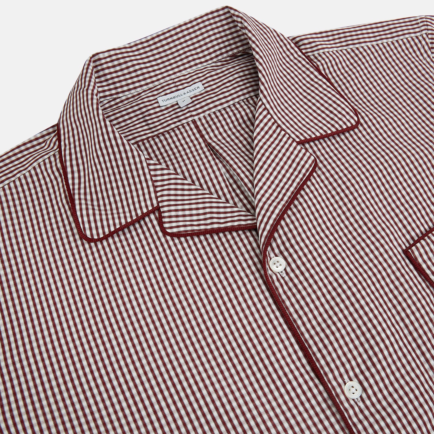 View 2 of product The Turnbull & Asser Burgundy Micro Check Winston Long Nightshirt is knee-length with long sleeves, brown and white micro checks, a collar, chest pocket with piping, and a front button placket.
