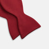 View 3 of product The Turnbull & Asser BURGUNDY SATIN BOW TIE features a deep red, smooth, and shiny finish—an essential accessory—neatly tied and showcased against a plain white background.