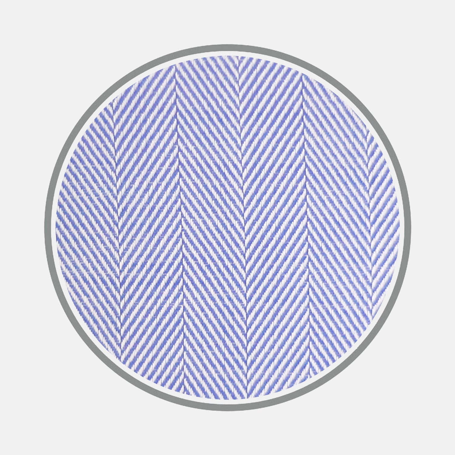 View 1 of product Close-up of a circular swatch of Turnbull & Asser’s Blue Herringbone Cotton Fabric, featuring a light blue diagonal zigzag pattern bordered in gray on a white background.