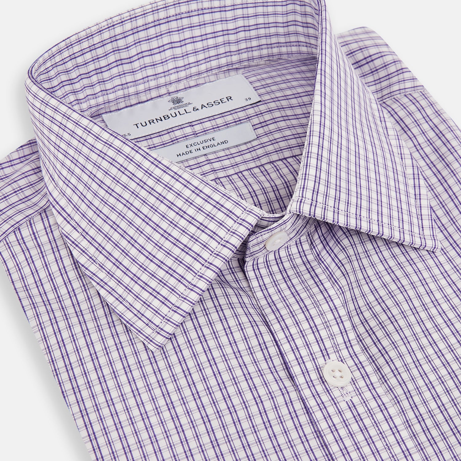 View 2 of product The Turnbull & Asser Purple Double Graph Check Mayfair Shirt is a long-sleeved, button-up dress shirt with a T&A collar and small blue and white check pattern, shown against a white background.